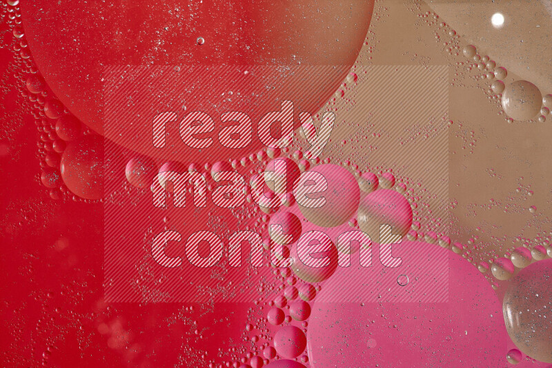 لقطات مقربة لفقاعات من الزيت على سطح الماء باللون البني والأحمر والوردي