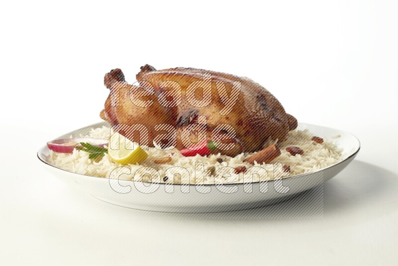 white  basmati Rice with  whole roasted chicken  on a white plate with a silver rim direct  on white background