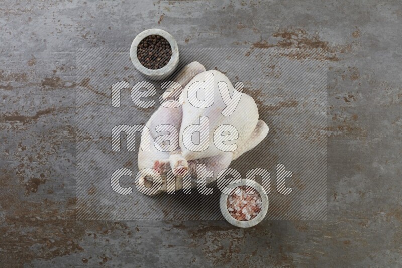 whole raw chicken  direct on a rustic grey background