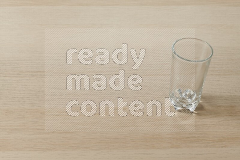 An empty glass cup on light wooden background