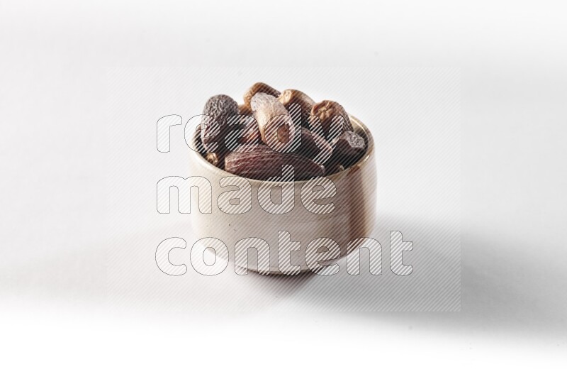 Dates in a beige pottery bowl on white background