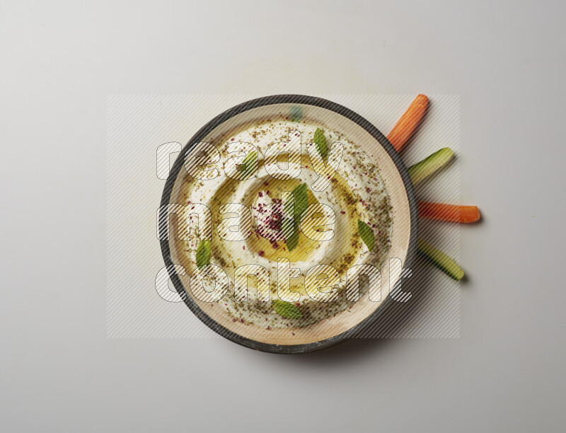 Lebnah garnished with zaater, mint & sumak in a pottery plate on a white background