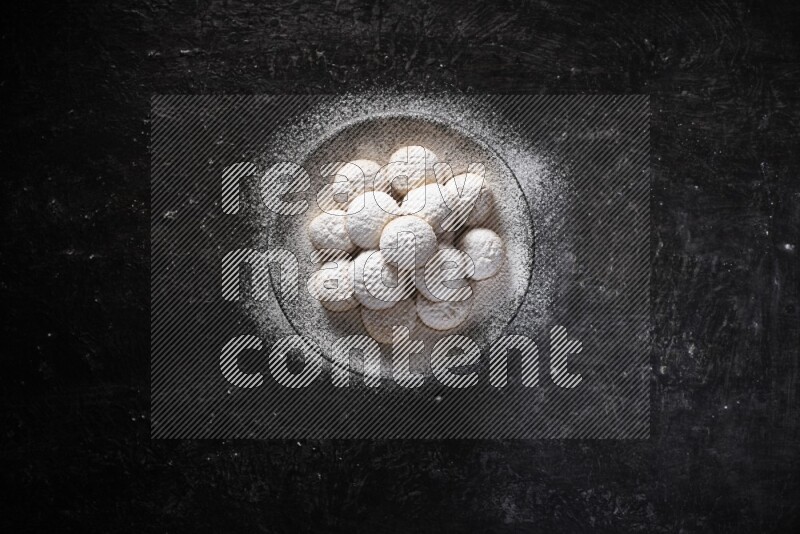 Kahk on a serving plate on a black background