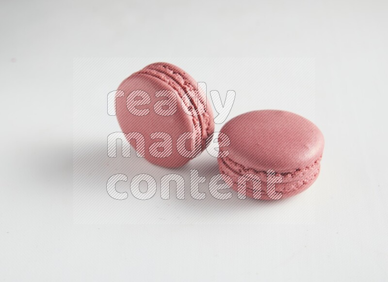 45º Shot of two Pink Raspberry macarons on white background