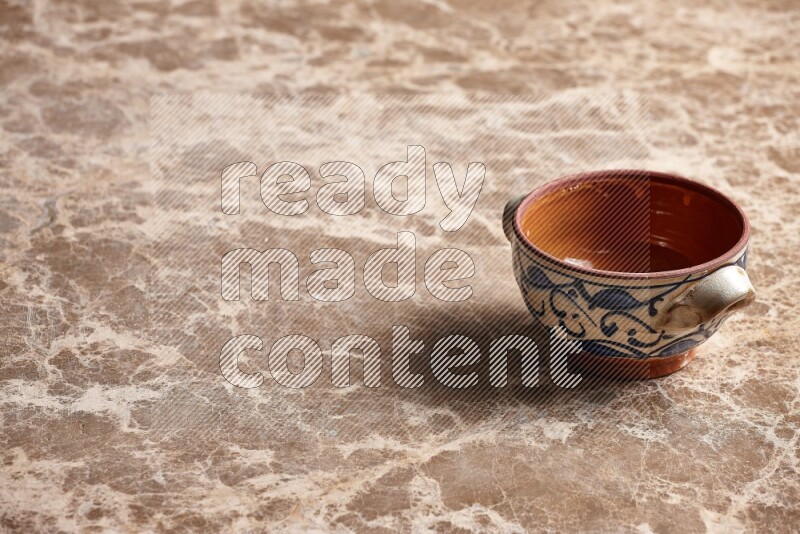 A decorative pottery bowl on beige marble background