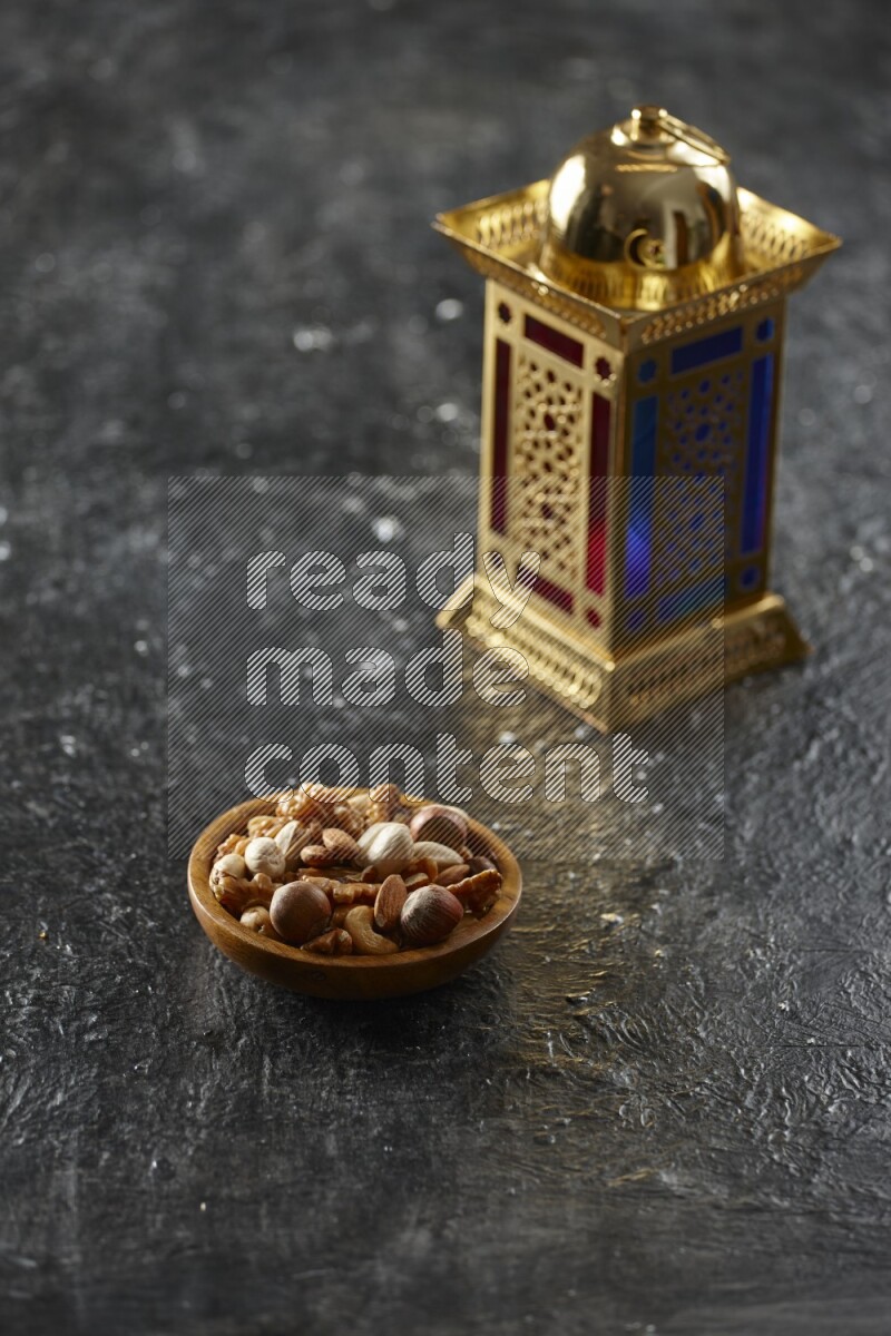 A golden lantern with different drinks, dates, nuts, prayer beads and quran on textured black background