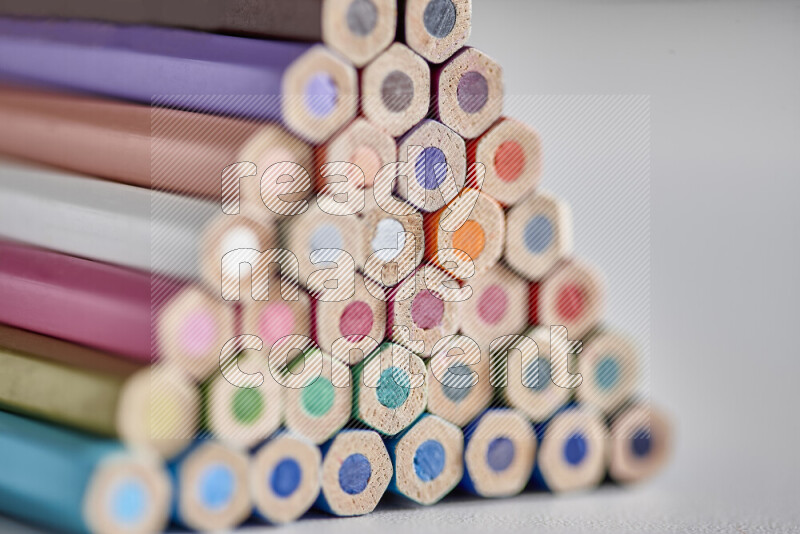 A close-up of the tips of colored pencils arranged in a bundle on white background