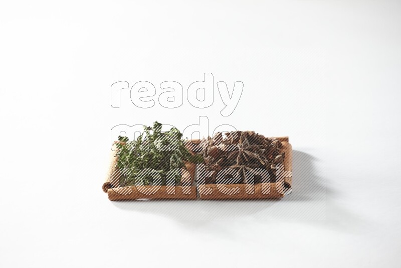 2 squares of cinnamon sticks full of star anise and dried mint leaves on white flooring