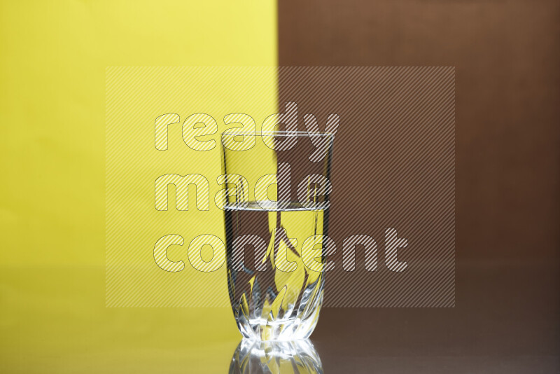 The image features a clear glassware filled with water, set against yellow and brown background