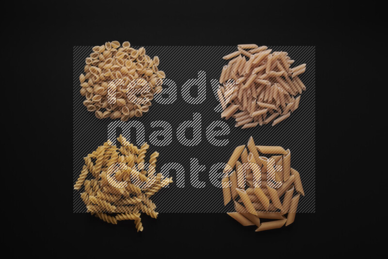 Different pasta types in bunches on black background
