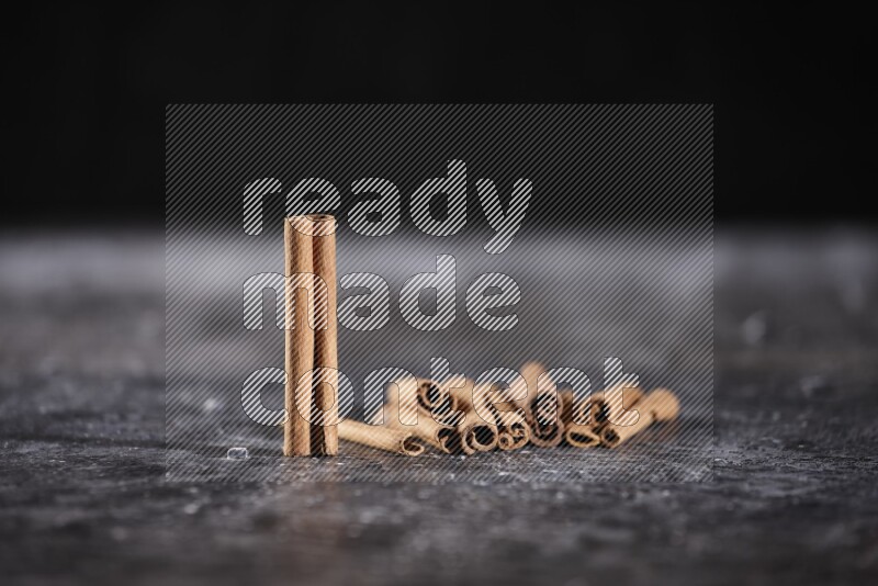 Cinnamon sticks on a textured black background