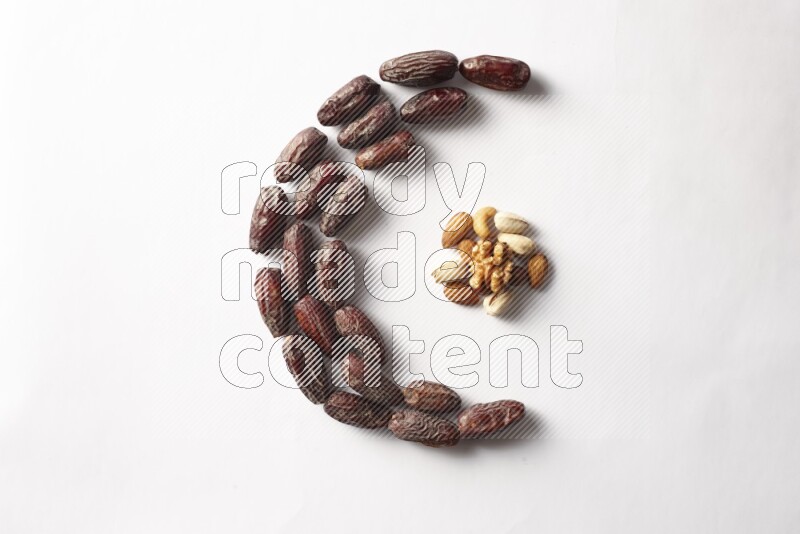 Dates in a crescent shape with nuts on white background