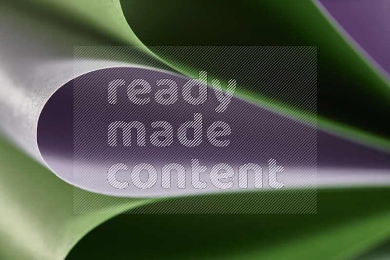 An abstract art showing purple and green paper sheets arranged in an overlapping curves