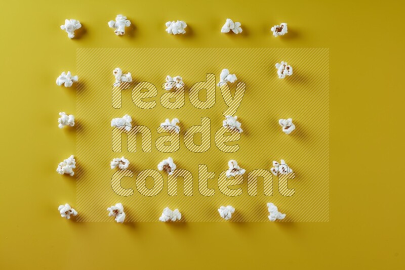 Popcorn flakes on a yellow background in different angles
