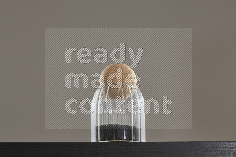 حبة البركة في وعاء زجاجي على خلفية سوداء