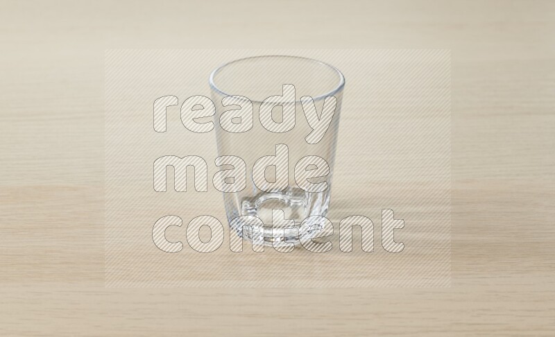 An empty glass cup on light wooden background