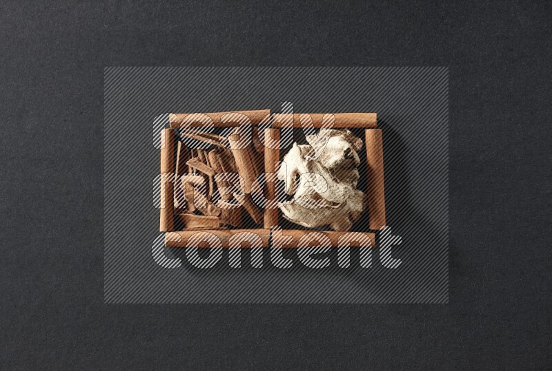 2 squares of cinnamon sticks full of cinnamon and ginger on black flooring