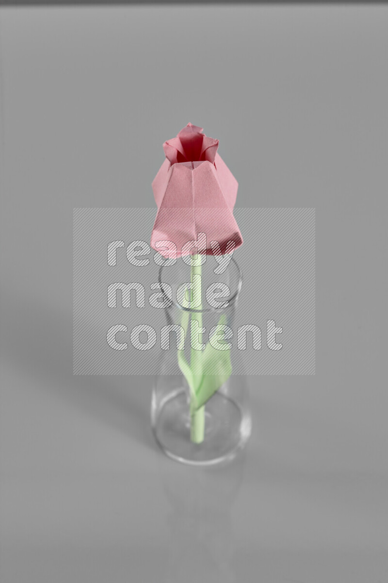 Origami flower on grey background