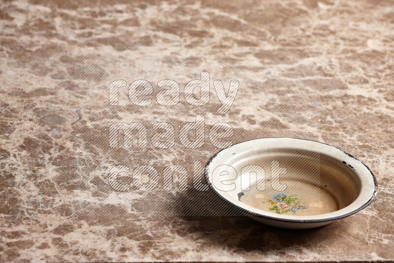 A vintage metal plate on beige marble background