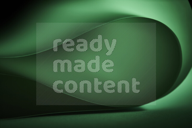 An abstract art piece displaying smooth curves in green gradients created by colored light