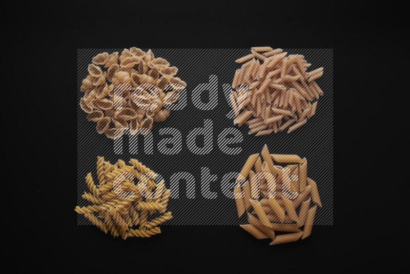 Different pasta types in bunches on black background