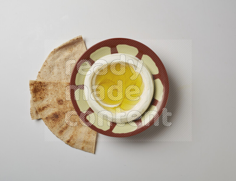Lebnah garnished with olive oil in a traditional plate on a white background
