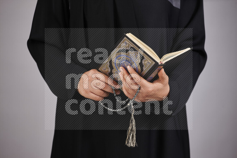 A woman hands holding moshaf in different positions