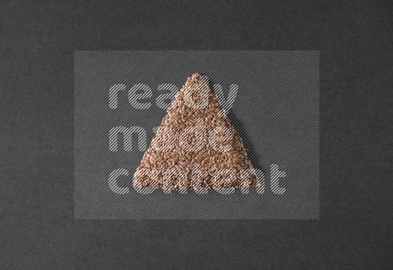 Flax Seeds in a triangle shape on a black Flooring