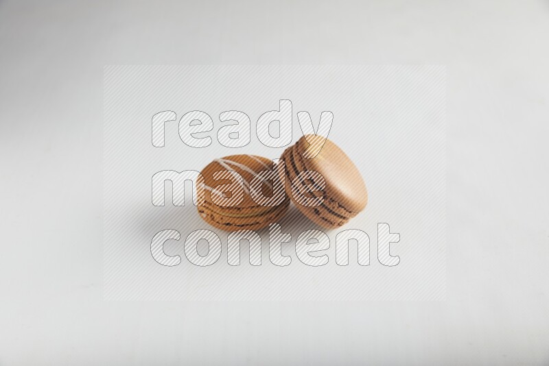 45º Shot of of two assorted Brown Irish Cream, and Brown Coffee macarons  on white background
