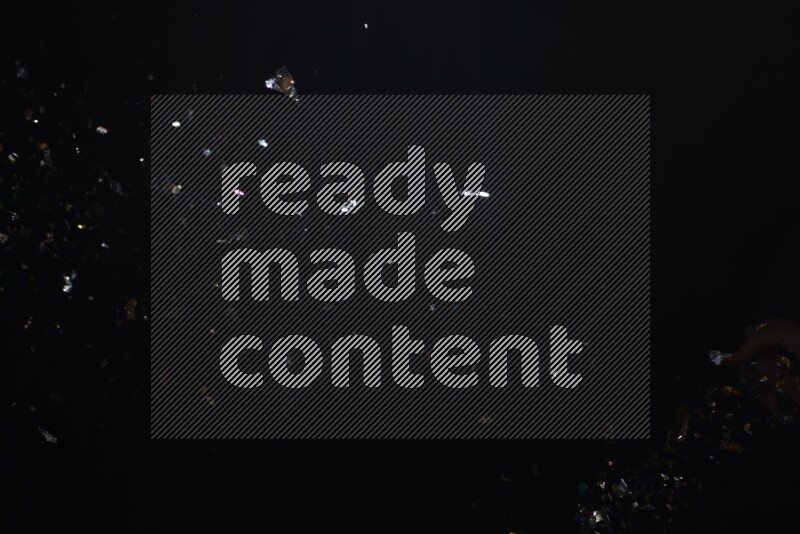 Falling multicolored confetti on black background