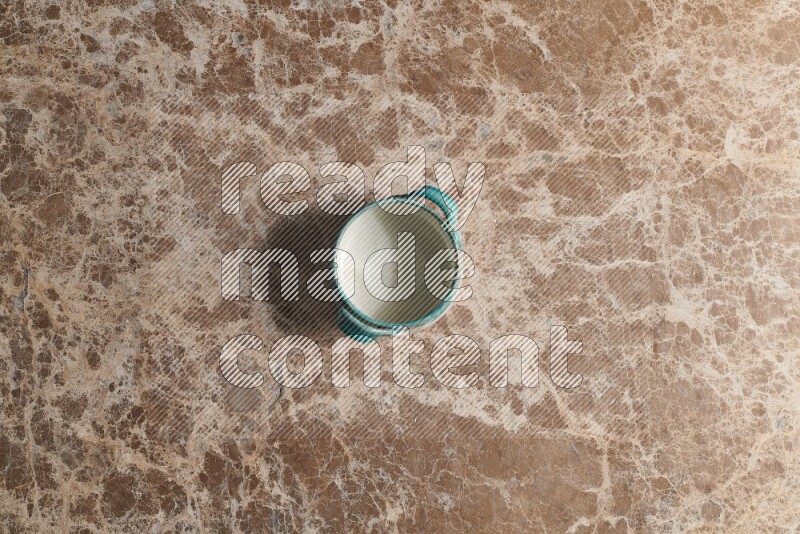 A multicolored pottery bowl on beige marble background