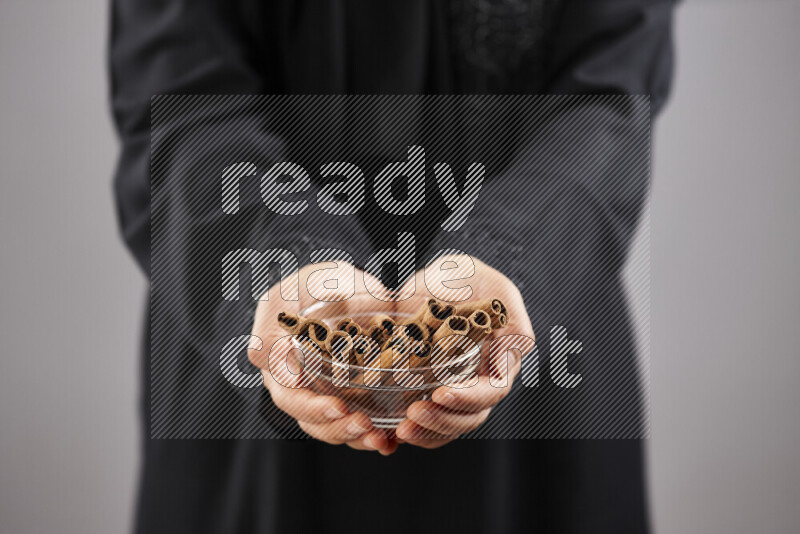 Woman in abaya holding different kinds of spices in different positions