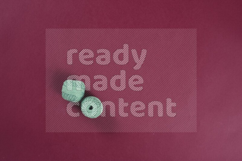 مجموعة من أدوات الخياطة والتفصيل خضراء وحمراء اللون على خلفية حمراء