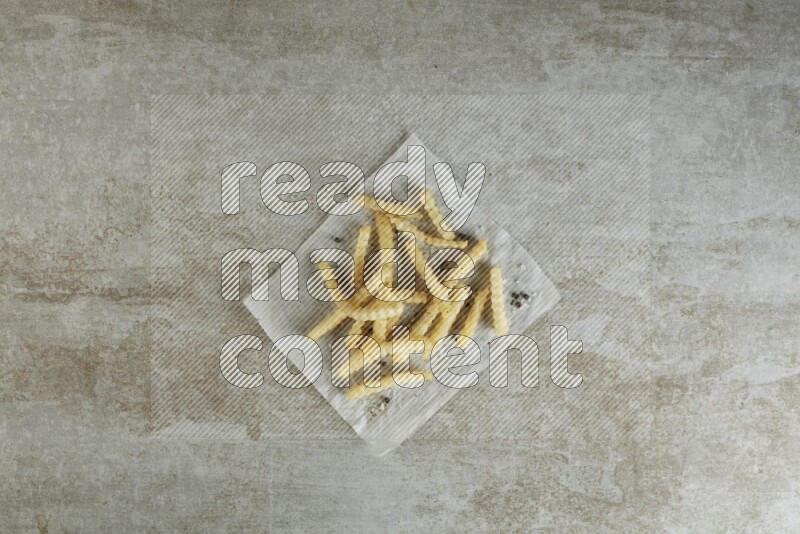 crinkle fries on parchment paper on grey textured counter top
