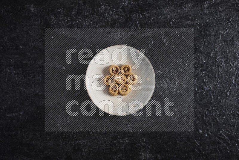 كنافة في صحن فخاري علي خلفية سوداء خشبية