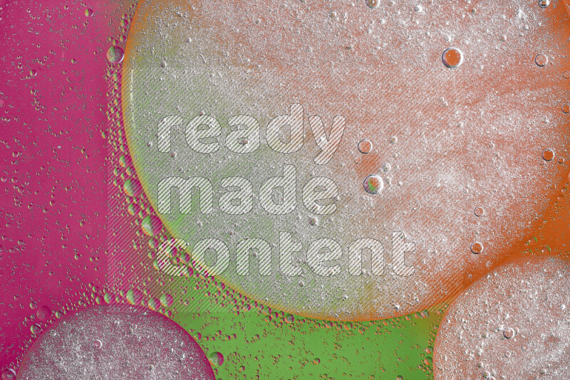 Close-ups of abstract oil bubbles on water surface in shades of orange, green and pink