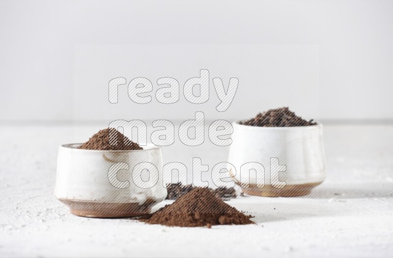 وعاءين من السيراميك بيج اللون، أحدهما مملوء بالقرنفل والآخر مملوء بالبودرة على أرضية بيضاء