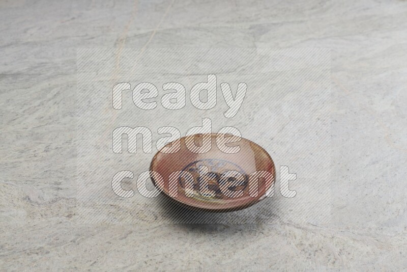A decorative pottery plate on grey marble background