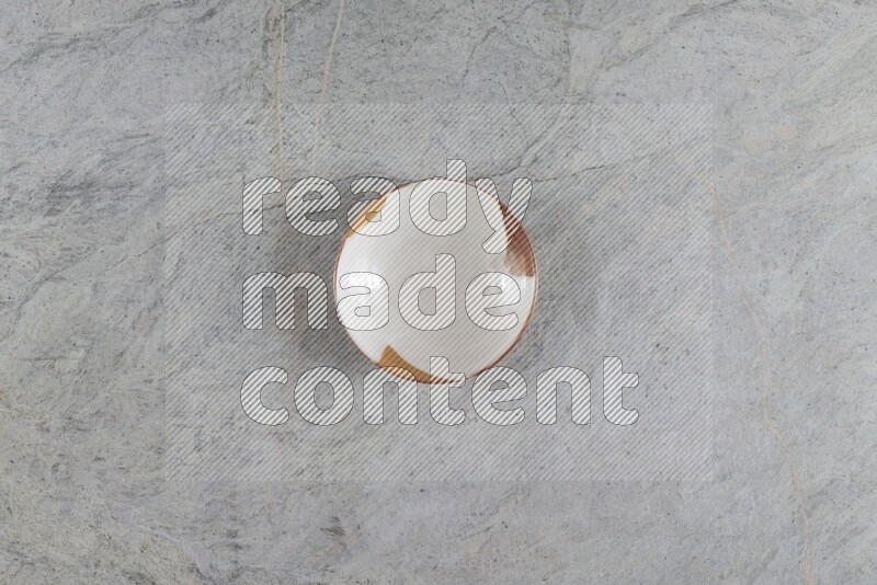 A multicolored pottery plate on grey marble background