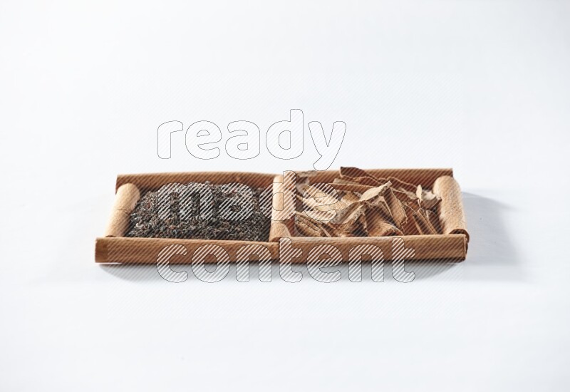 2 squares of cinnamon sticks full of black tea and cinnamon on white flooring