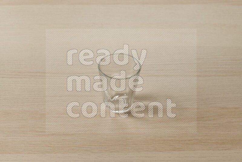 كوب فارغ زجاجي علي خلفية خشبية فاتحة