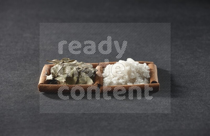 2 squares of cinnamon sticks full of salt and bay laurel on black flooring