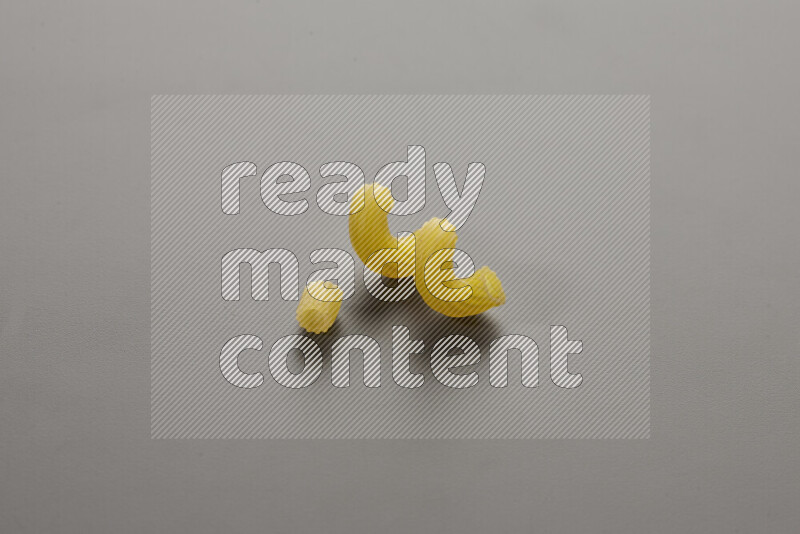 Small rings pasta with other types of pasta on grey background