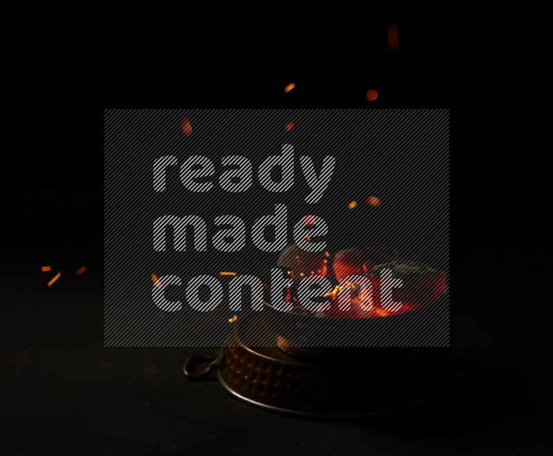 Coal cubes on fire in metal pan