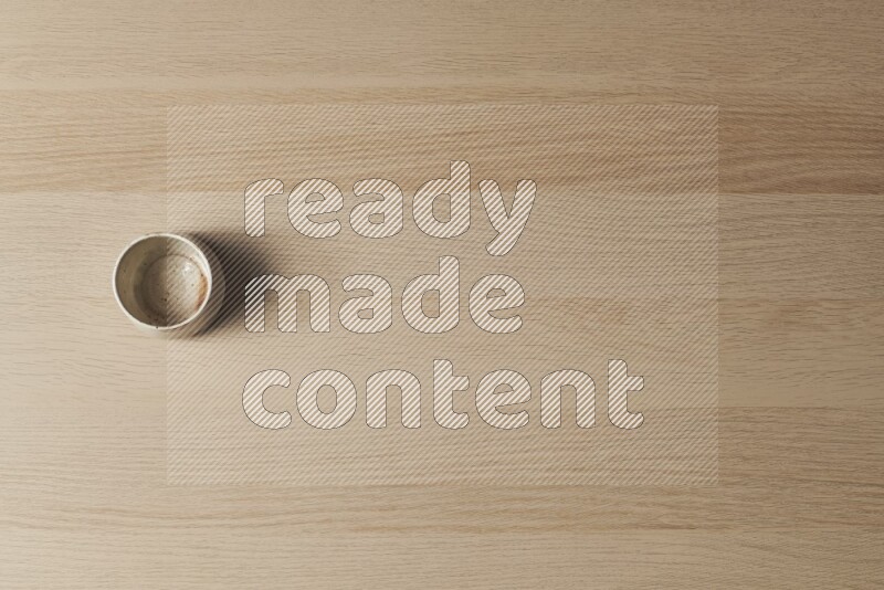 A multicolored pottery bowl on light wooden background