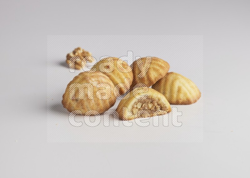 Five Pieces of Maamoul filled with walnut paste  one of them is cut with direct on white background