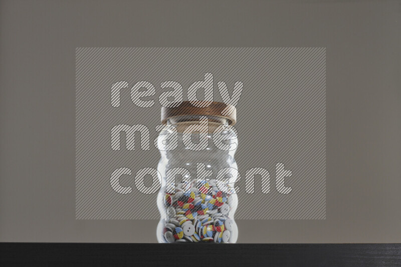 أزرار متنوعة في وعاء زجاجي علي خلفية سوداء