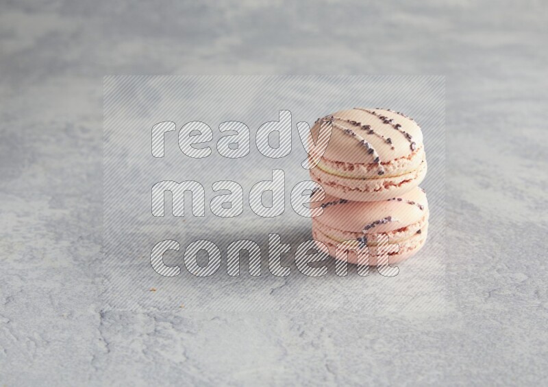 45º Shot of two pink orange blossom macarons  on white  marble background