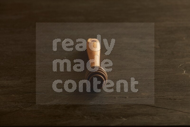 Wooden honey dipper on black slate background