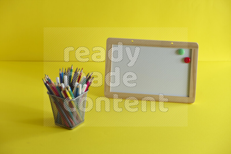 A whiteboard with different school supplies on yellow background